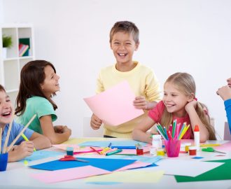 Little boy and his friends laughing in classroom